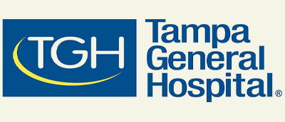 Logo for Tampa General Hospital. The image features a blue box with "TGH" in white letters and a yellow swoosh underneath. To the right, the text "Tampa General Hospital" is written in blue.